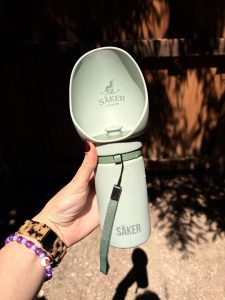 Säker dog water bottle in light blue being held by a woman's hand